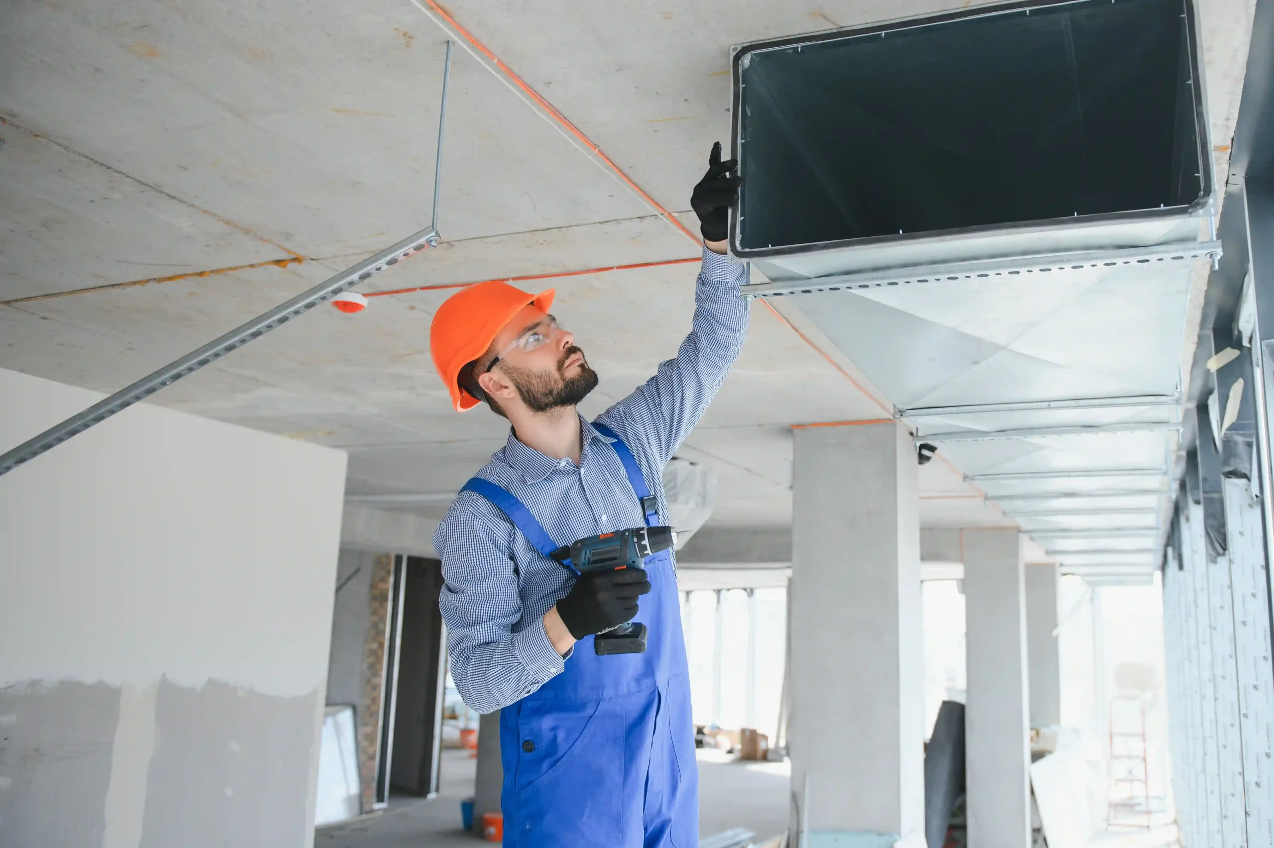 industrial theme warehouse heating and cooling system installation by professional caucasian technician commercial building ventilation rectangle canals air distribution photo